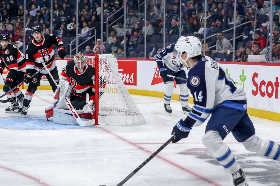 Hockey player carrying puck toward net